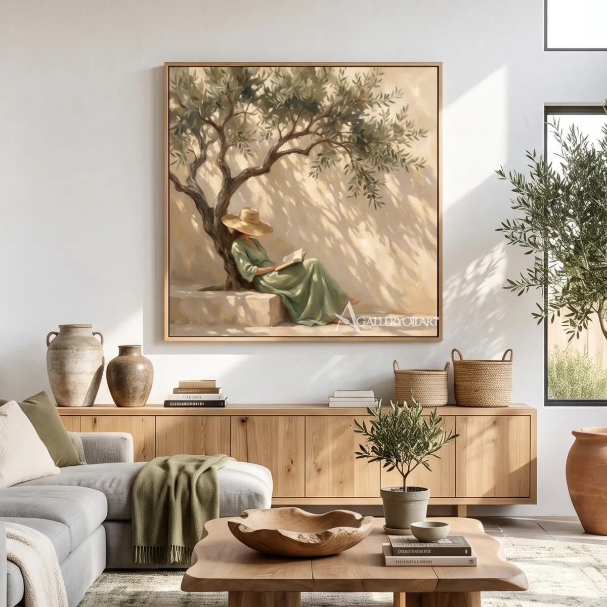 A woman reads beneath an olive tree in square Portrait Art above a wood console in a natural living room, with beige and sage tones