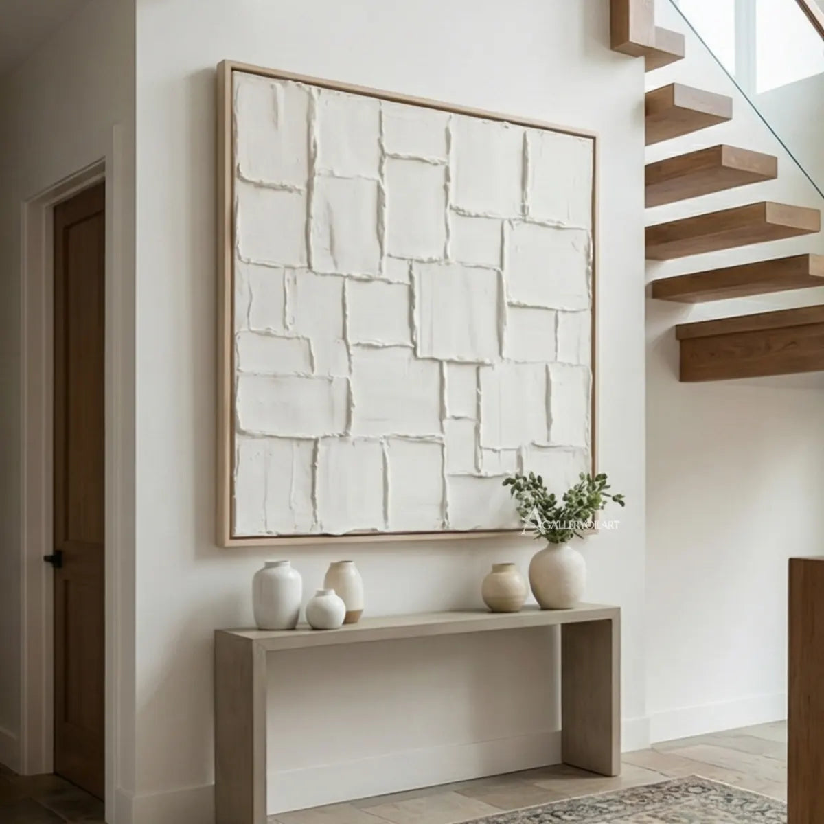 Raised-white-grid-textured-3D-wall-art-above-a-console-beside-floating-stairs